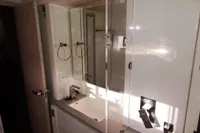 Modern bathroom in 2017 Leopard 43 Powercat with sink, mirror, and storage cabinets.