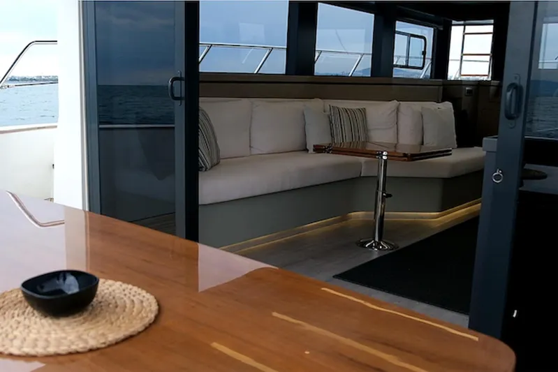  Yacht Photos Pics Luxurious interior of 2023 Custom DG CAT 43 yacht with elegant seating and wooden table.