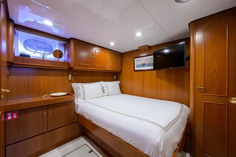 Aventurer Yacht Photos Pics Luxurious cabin interior of 1986 Jongert 85 yacht with wood paneling and cozy bed.