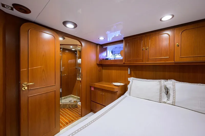 Aventurer Yacht Photos Pics Luxurious wooden cabin interior on 1986 Jongert 85 yacht, featuring elegant bedding and cabinetry.