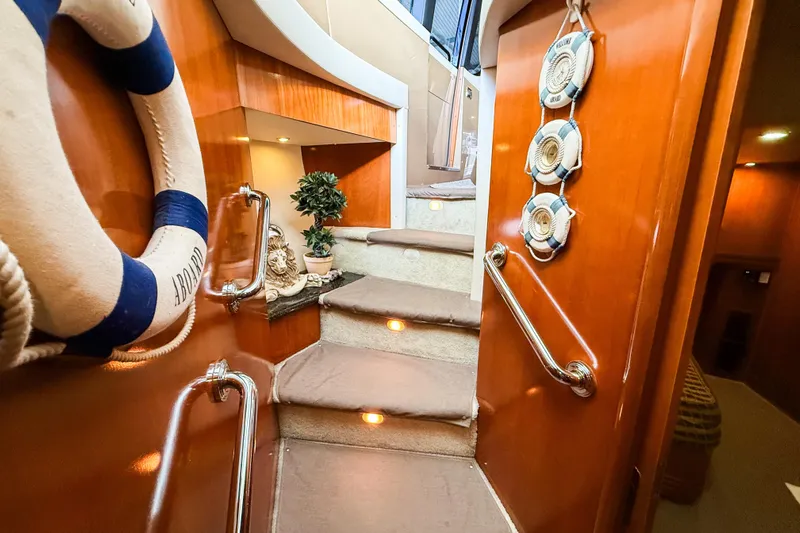 Over And Out Yacht Photos Pics Interior of 2001 Carver 570 Voyager Pilothouse with wooden stairs and nautical decor.