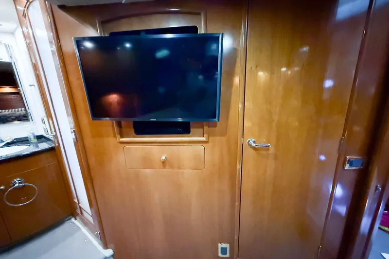 Over And Out Yacht Photos Pics Interior of 2001 Carver 570 Voyager Pilothouse with mounted TV and wooden cabinetry.