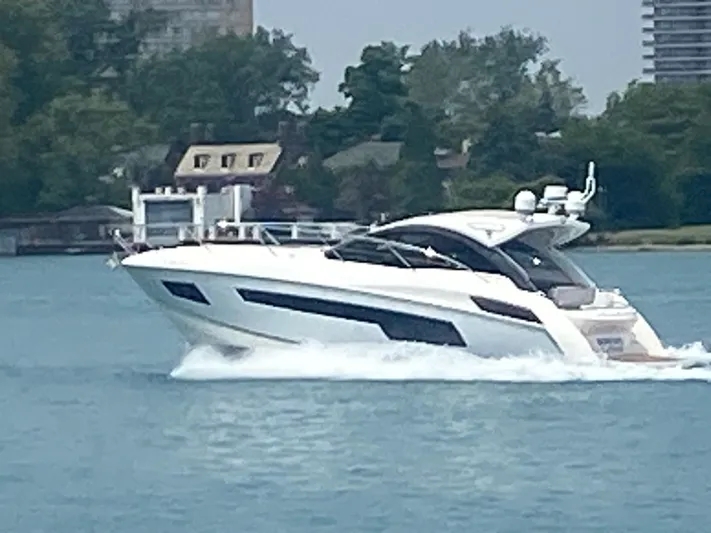 Work Hard, Play Hard Yacht Photos Pics 2013 Sunseeker Portofino 40 yacht cruising on a serene waterway.