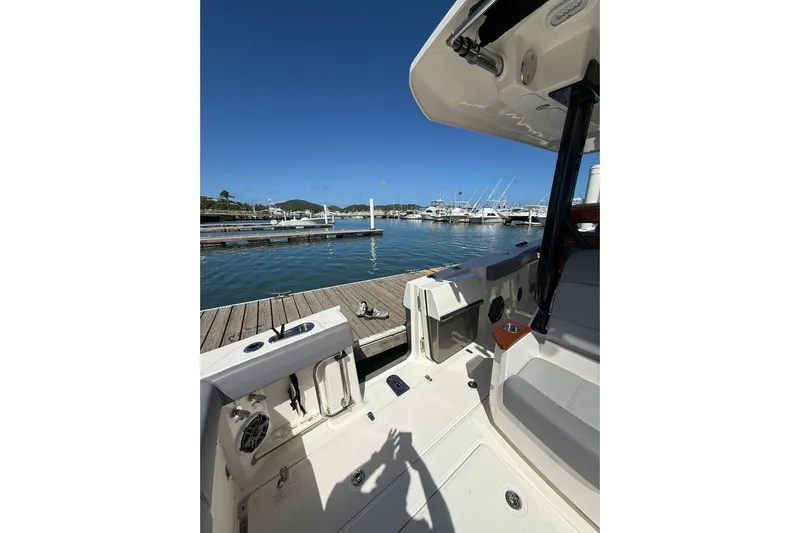  Yacht Photos Pics 2023 Boston Whaler 360 Outrage docked at marina, showcasing spacious deck and seating.