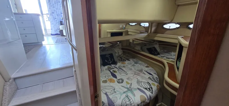 Saga Yacht Photos Pics Interior of 1999 Sea Ray 480 Sedan Bridge, featuring cozy cabin with nautical-themed bedding.