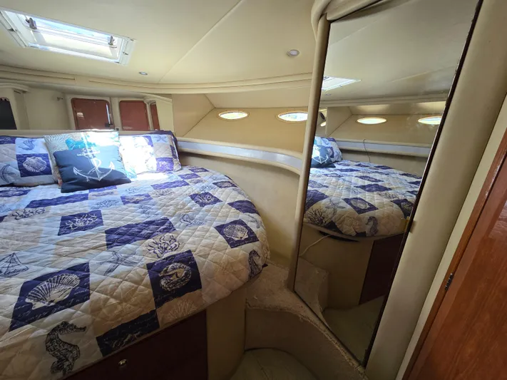 Saga Yacht Photos Pics 1999 Sea Ray 480 Sedan Bridge cabin with quilted bedspread and mirrored closet.