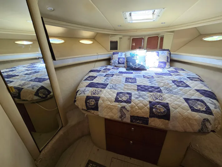 Saga Yacht Photos Pics Cozy bedroom in 1999 Sea Ray 480 Sedan Bridge yacht with nautical-themed bedding.