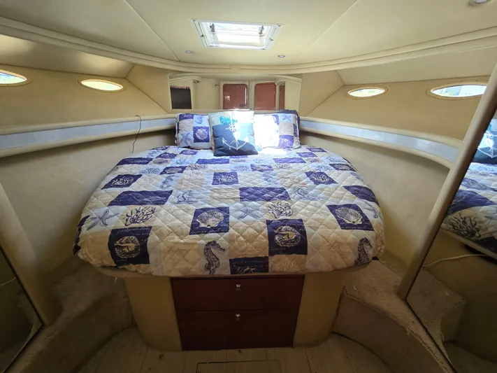 Saga Yacht Photos Pics 1999 Sea Ray 480 Sedan Bridge cabin with a cozy bed and nautical-themed quilt.