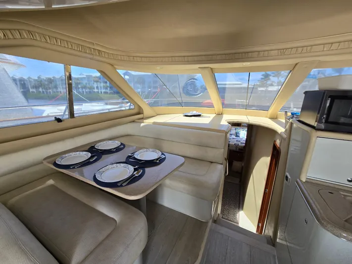 Saga Yacht Photos Pics Interior of 1999 Sea Ray 480 Sedan Bridge with dining area and panoramic windows.