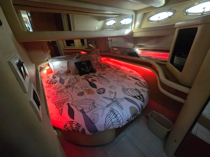 Saga Yacht Photos Pics Luxurious 1999 Sea Ray 480 Sedan Bridge cabin with ambient red lighting and nautical-themed bedding.