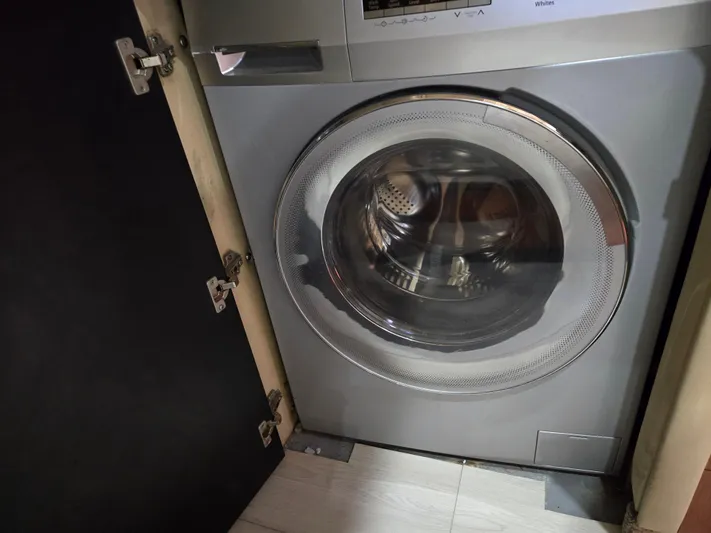 Saga Yacht Photos Pics Front-loading washing machine in a cabinet on a 1999 Sea Ray 480 Sedan Bridge.