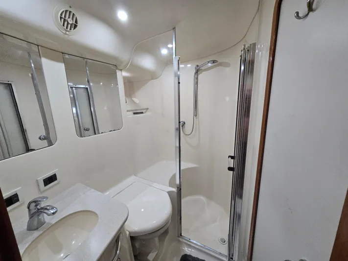 Saga Yacht Photos Pics 1999 Sea Ray 480 Sedan Bridge bathroom with shower, sink, and mirror.