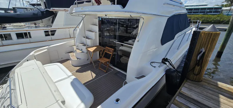 Saga Yacht Photos Pics 1999 Sea Ray 480 Sedan Bridge yacht docked, featuring outdoor seating and elegant design.