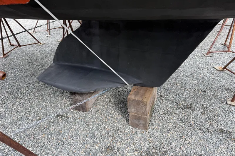  Yacht Photos Pics 2023 Catalina 315 sailboat keel supported on wooden blocks, gravel ground.