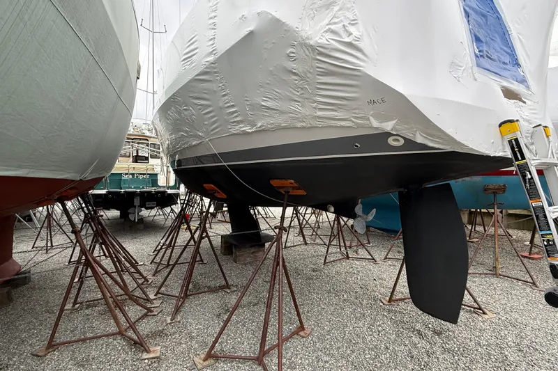  Yacht Photos Pics 2023 Catalina 315 sailboat in dry dock, supported by stands, with protective covering.