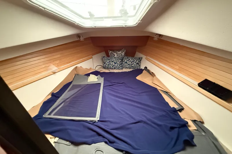  Yacht Photos Pics 2023 Catalina 315 yacht interior cabin with cozy bedding and wooden paneling.