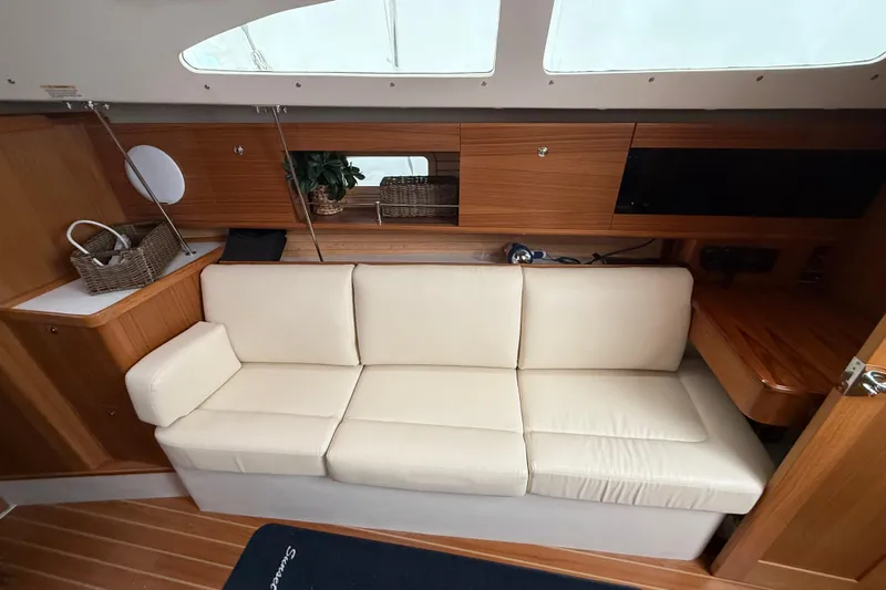  Yacht Photos Pics Interior of 2023 Catalina 315 yacht with cream sofa and wooden cabinetry.