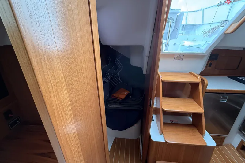  Yacht Photos Pics 2023 Catalina 315 yacht interior with wooden stairs and compact cabin space.