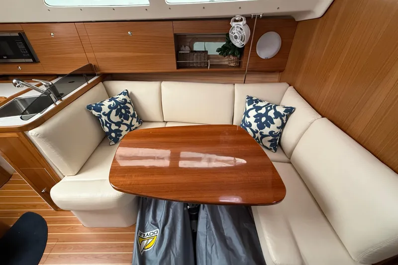  Yacht Photos Pics 2023 Catalina 315 yacht interior with cozy seating and elegant wooden table.