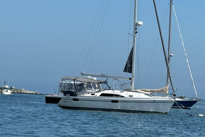  Yacht Photos Pics 2023 Catalina 315 sailboat anchored in calm waters under a clear blue sky.