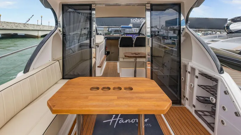 Custom Order Your 415 Today! Yacht Photos Pics Luxurious Hanover 415 yacht interior with wooden table, seating, and open sliding doors, 2025 model.