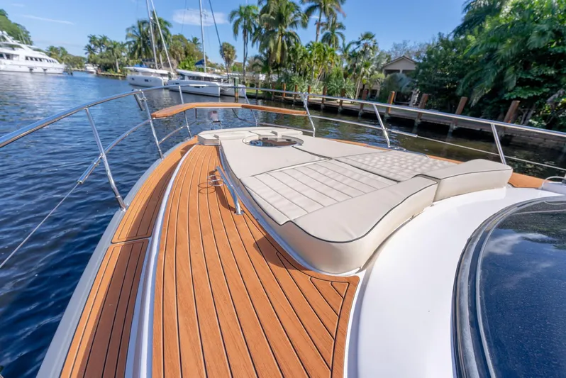 Custom Order Your 415 Today! Yacht Photos Pics Luxurious Hanover 415 yacht deck with sunbed, docked near lush greenery, 2025 model.