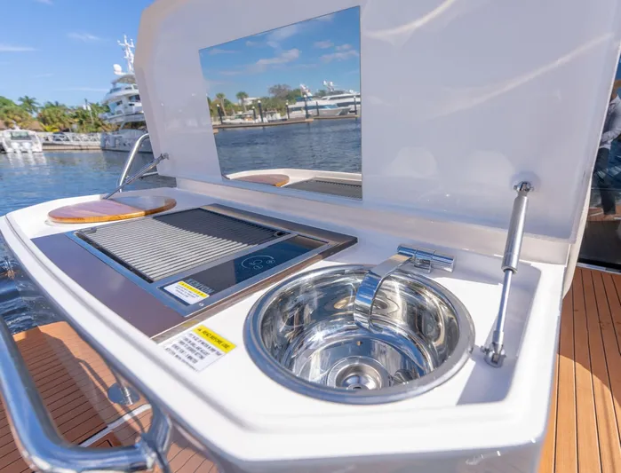 Custom Order Your 415 Today! Yacht Photos Pics Outdoor kitchen on Hanover 415 yacht, featuring a grill and sink, docked by the water.