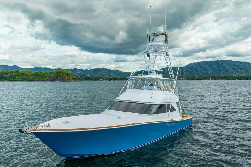 Watts Up Yacht Photos Pics 2016 Viking 66 Convertible yacht on scenic water with cloudy sky and lush hills.
