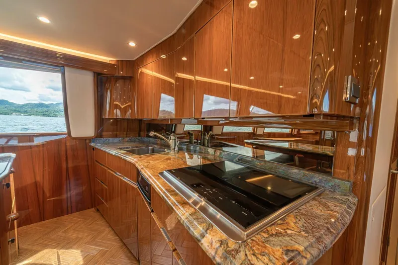 Watts Up Yacht Photos Pics Luxurious kitchen interior of 2016 Viking 66 Convertible yacht with wood cabinetry and ocean view.