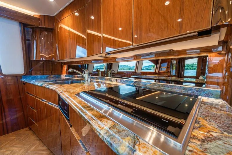 Watts Up Yacht Photos Pics Luxurious kitchen interior of 2016 Viking 66 Convertible yacht with sleek wood finishes.