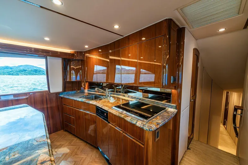 Watts Up Yacht Photos Pics Luxurious kitchen interior of 2016 Viking 66 Convertible yacht with wood finish and ocean view.