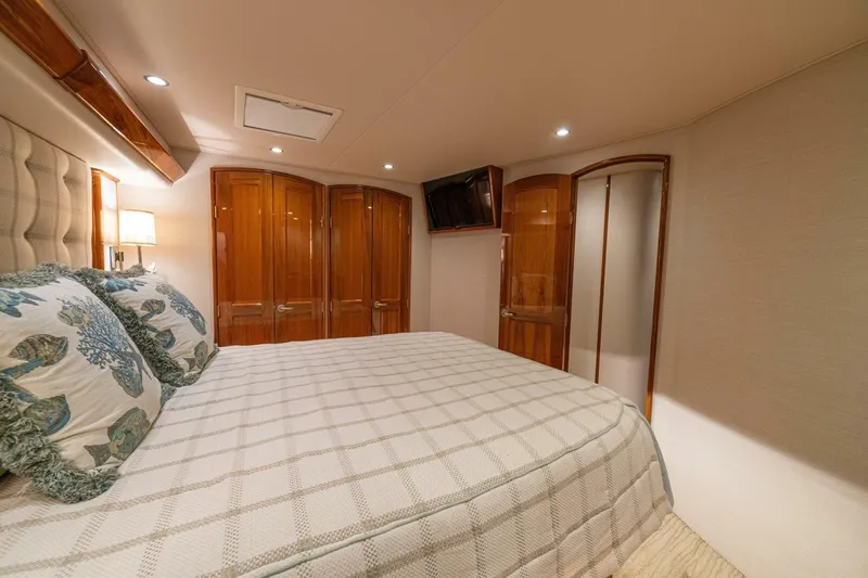 Watts Up Yacht Photos Pics Luxurious bedroom interior of 2016 Viking 66 Convertible yacht with elegant wood finishes.