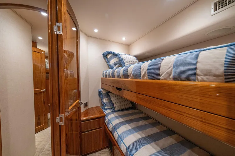 Watts Up Yacht Photos Pics Interior of 2016 Viking 66 Convertible yacht with cozy bunk beds and wooden finishes.