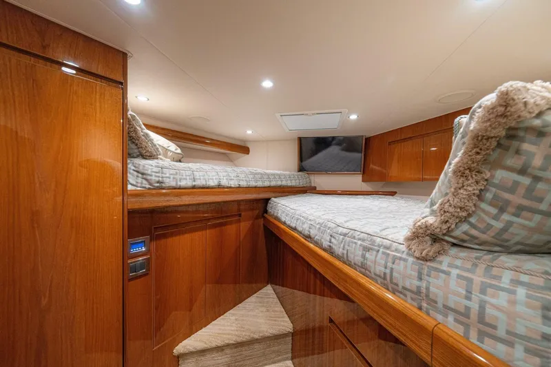 Watts Up Yacht Photos Pics Luxurious cabin interior of 2016 Viking 66 Convertible yacht with twin beds and wood finish.
