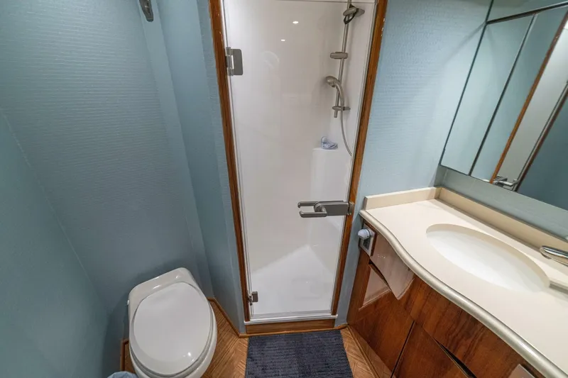 Watts Up Yacht Photos Pics Bathroom interior of 2016 Viking 66 Convertible yacht with shower, toilet, and sink.