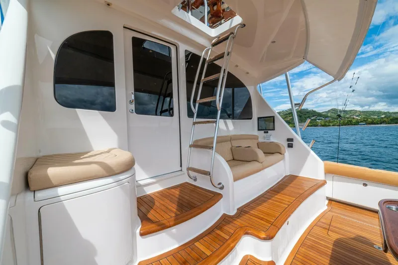 Watts Up Yacht Photos Pics 2016 Viking 66 Convertible yacht with teak deck, cushioned seating, and ladder, overlooking scenic waters.