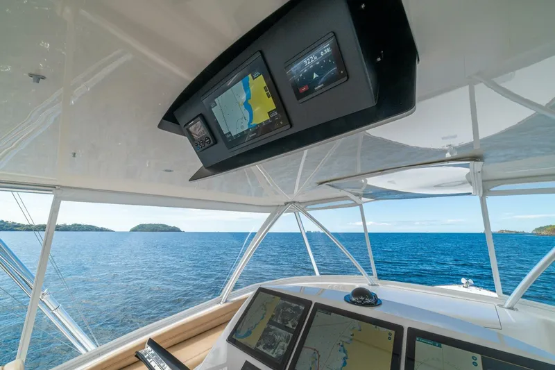 Watts Up Yacht Photos Pics Interior view of 2016 Viking 66 Convertible yacht with navigation screens and ocean backdrop.