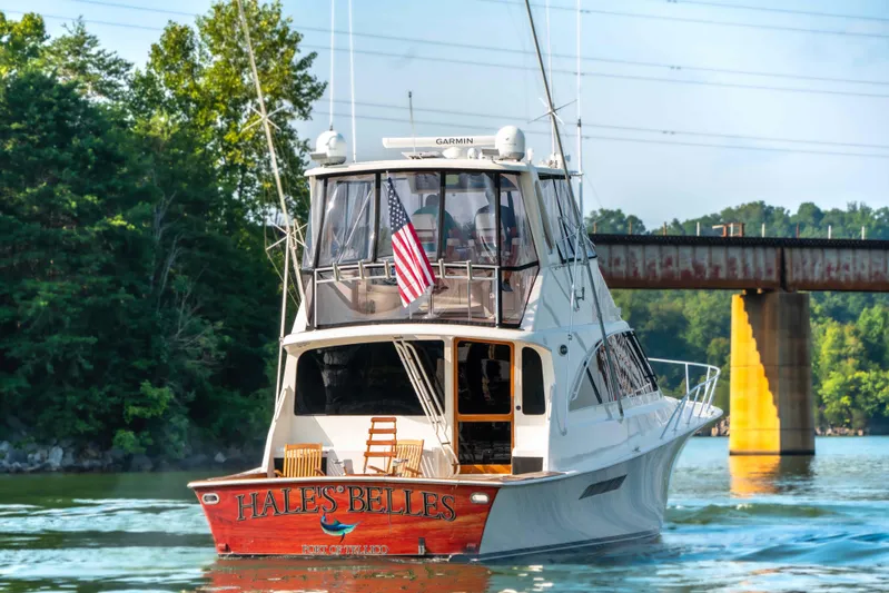  Yacht Photos Pics 1997 Ocean Yachts 60 Sport Fish boat cruising on a river near a bridge.