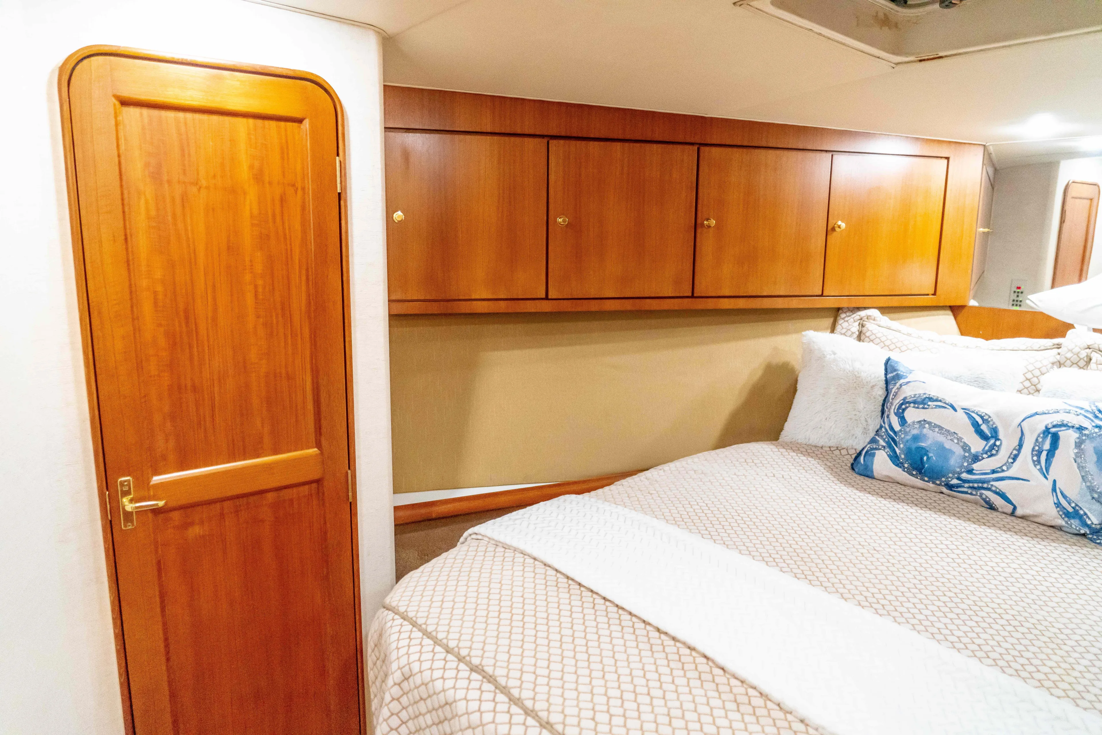  Yacht Photos Pics 1997 Ocean Yachts 60 Sport Fish cabin with wooden cabinets and cozy bedding.