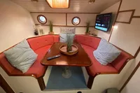 Cozy Custom Survey 55 yacht interior with red seating, table, and TV, built in 1997.
