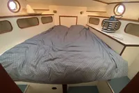Cozy cabin interior of 1997 Custom Survey 55 boat with double bed and portholes.