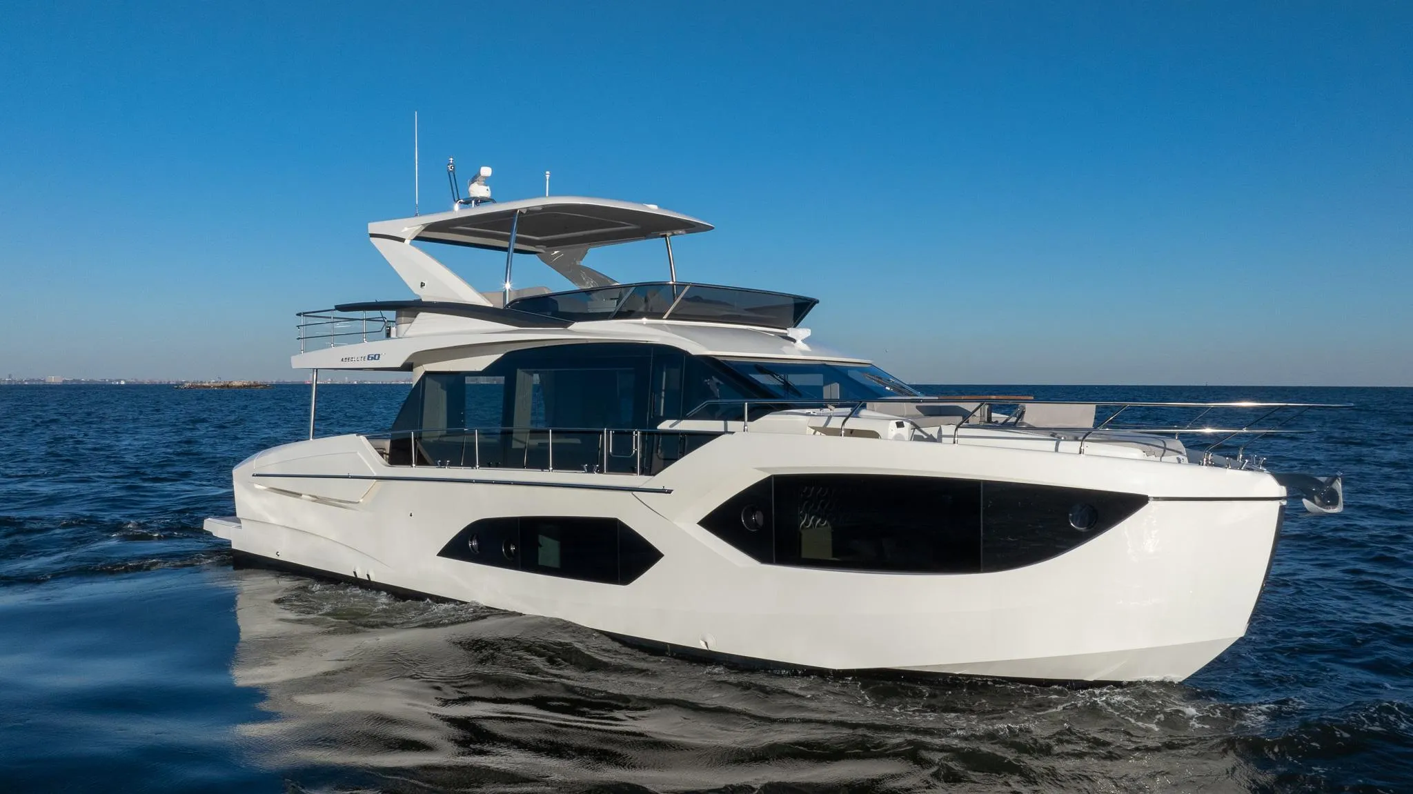 2025 Absolute 60 Fly yacht cruising on open water under clear blue sky.