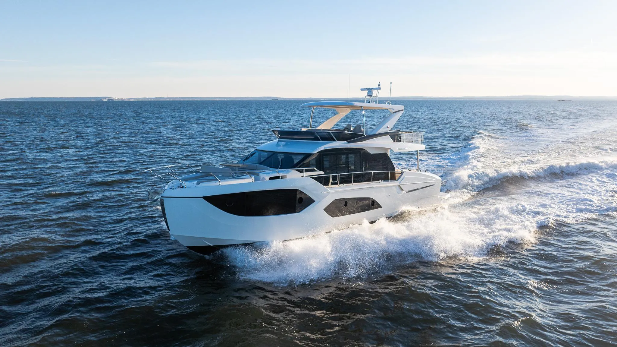 2025 Absolute 60 Fly yacht cruising on open water under clear skies.