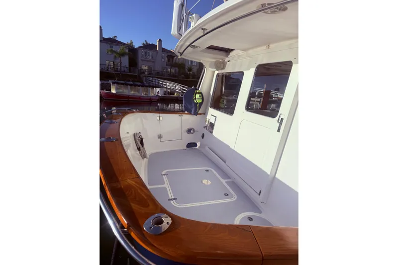 Blue Yacht Photos Pics 1989 Nordhavn 46 yacht deck with wooden railings and white cabin door.