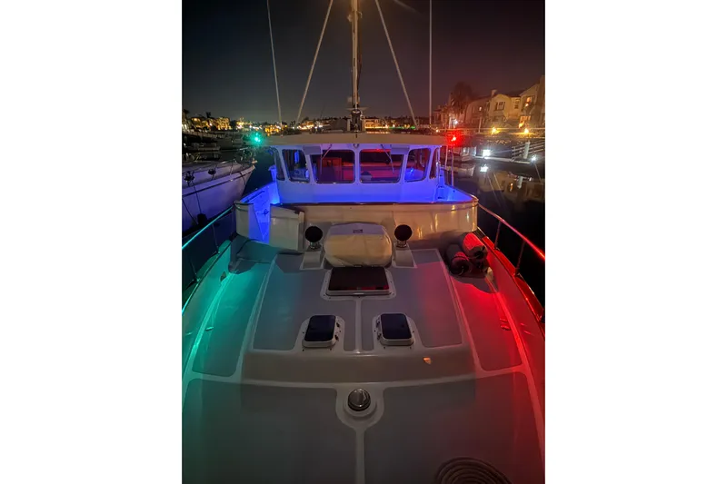 Blue Yacht Photos Pics 1989 Nordhavn 46 yacht illuminated at night with colorful deck lights.