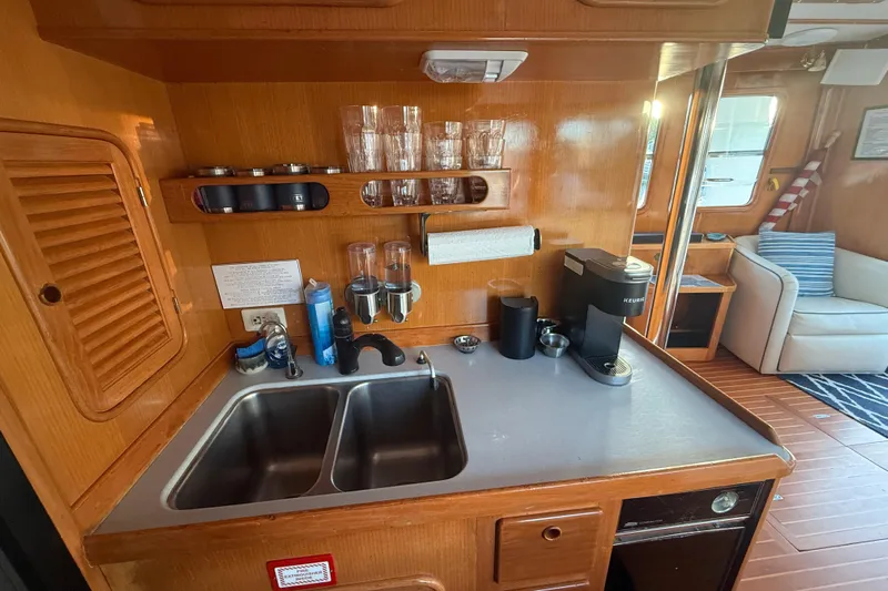Blue Yacht Photos Pics 1989 Nordhavn 46 yacht kitchen with wooden cabinetry, dual sink, and coffee maker.