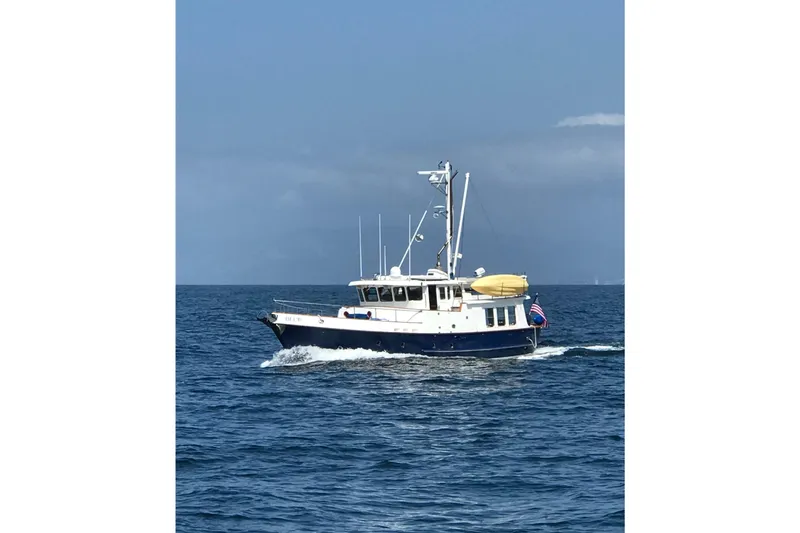 Blue Yacht Photos Pics 1989 Nordhavn 46 yacht cruising on open sea under clear blue sky.