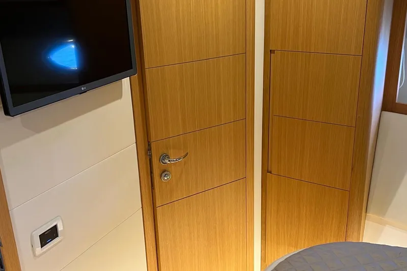  Yacht Photos Pics Interior of 2010 Pershing 56 yacht with wooden doors and mounted TV.