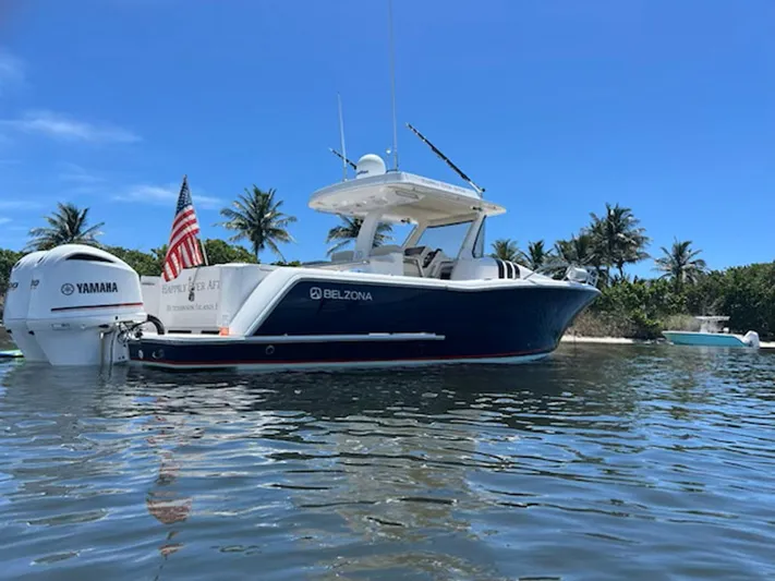Happily Ever After Yacht Photos Pics 2016 Belzona 327 WA boat on water, Yamaha engines, American flag, palm trees in background.