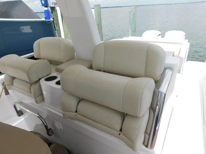 Happily Ever After Yacht Photos Pics Luxurious seating on a 2016 Belzona 327 WA boat, featuring beige cushioned chairs.